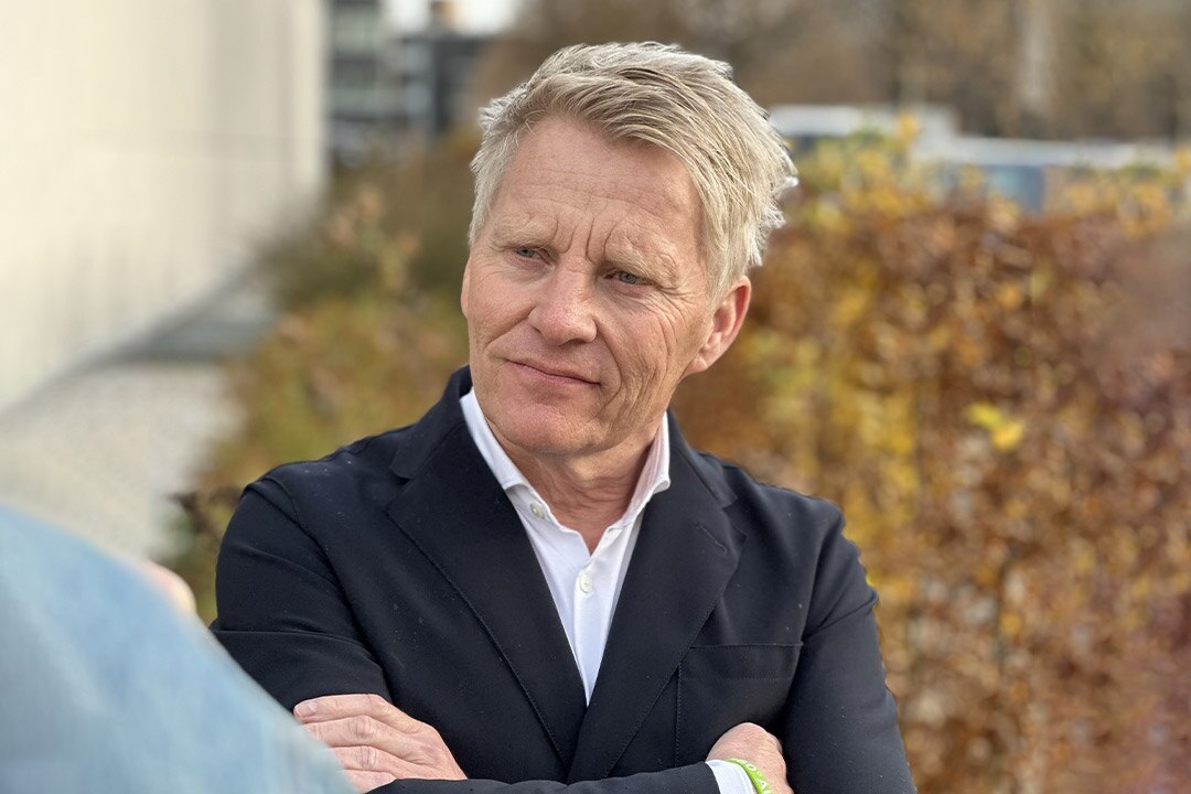 Homme en blazer noir à l’extérieur.