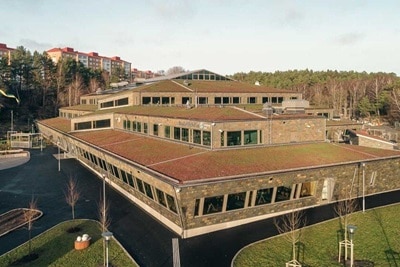 Aerial view of a modern building with green roof and surrounding landscape