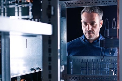 Professional examining an electrical cabinet with a focus on automation and control systems