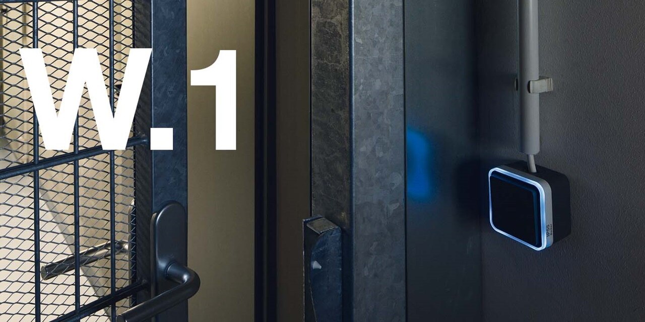 Modern access control keypad with illuminated blue edges on a dark textured wall
