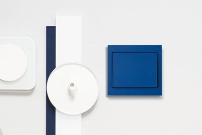 White and blue electrical wall switches mounted on wall
