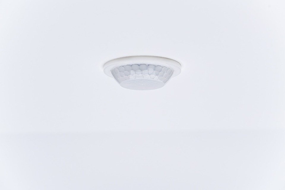Ceiling-mounted smoke detector in a white room