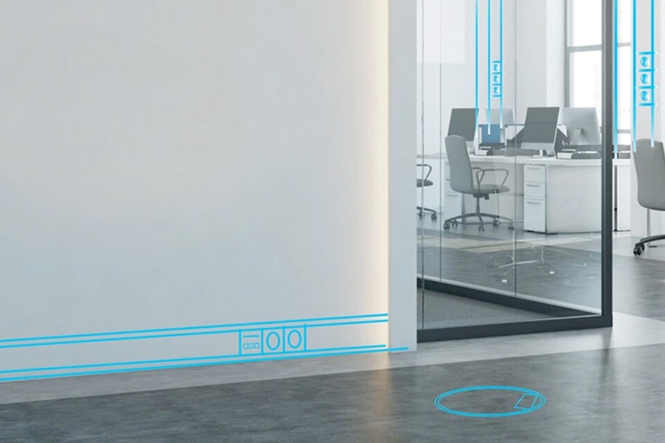 Espace de bureau moderne avec cloison en verre et système de conduit électrique mural visible