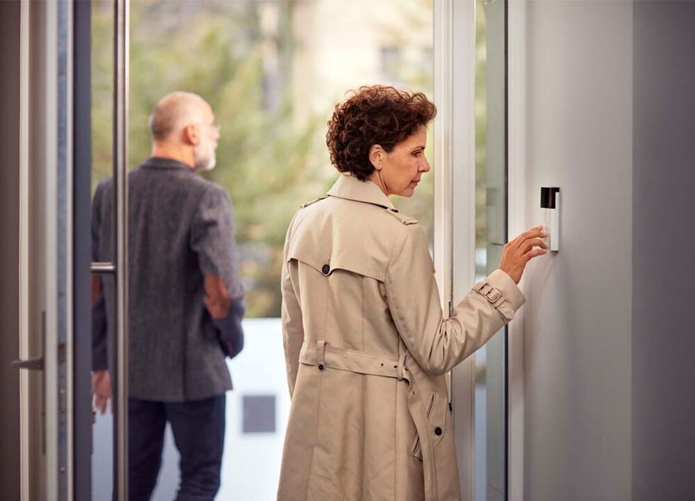Personne utilisant un clavier de contrôle d'accès mural à l'intérieur d'un bâtiment moderne