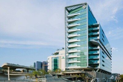 Bâtiment commercial moderne avec façade en verre arborant le logo du groupe Hager