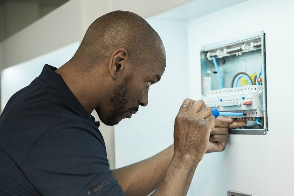 Technicien entretenant un tableau de distribution électrique