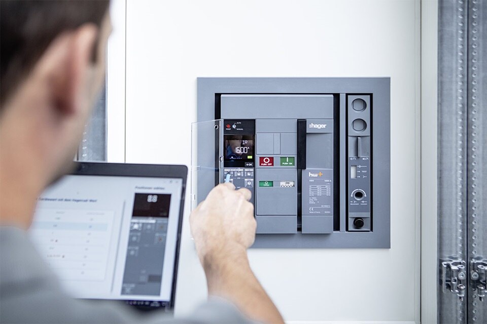Homme configurant un disjoncteur ouvert hw+ à l'aide du logiciel Hager Power setup