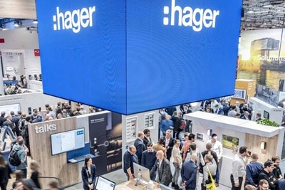 Immagine di una giornata in fiera nello stand Hager ripreso dall'alto, con in primo piano il pannello luminoso con il logo Hager bianco su sfondo blu