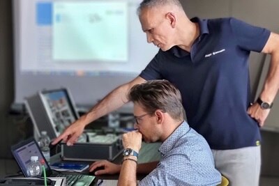 Installatore e tecnico in un momento formativo, intenti a provare una applicazione domotica con gli strumenti digitali