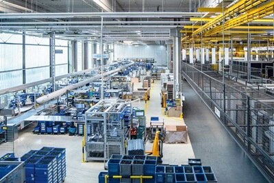 Interno di un impianto di produzione e assemblaggio Hager, con macchinari e postazioni operative per la realizzazione di soluzioni per installazioni elettriche.