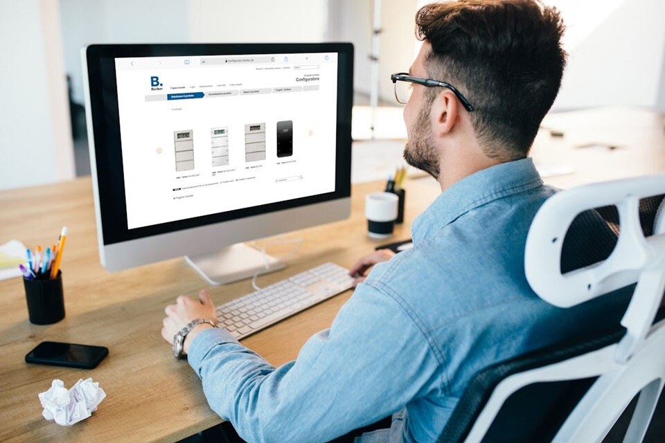 Immagine di un tecnico di spalle che utilizza il configuratore per la creazione di etichette per i comandi TS Sensor sul monitor del PC posizionato sulla scrivania da lavoro