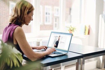 Donna seduta ad una scrivania di un ufficio che lavora al computer