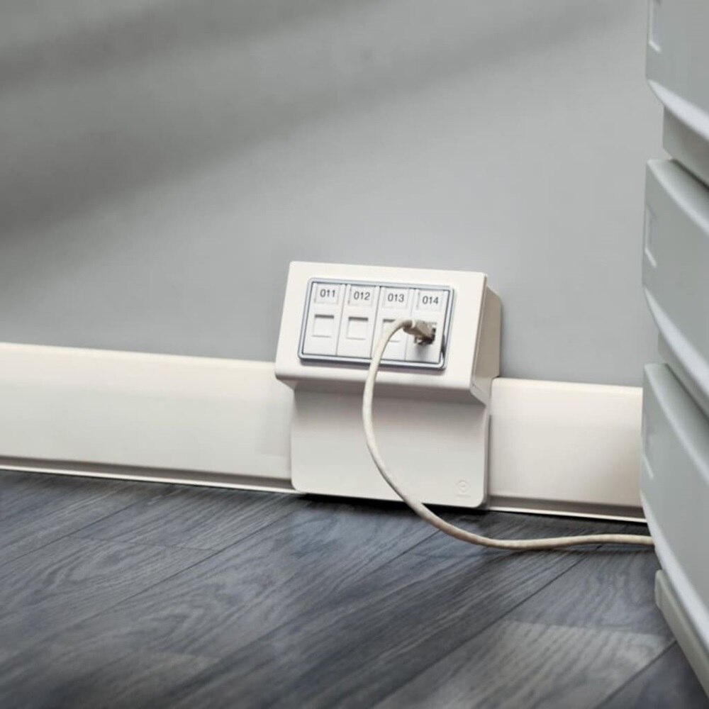 Dettaglio di una sala medica con sistema di canale battiscopa TBA Bocchiotti, dotato di scatola porta apparecchi bianca.