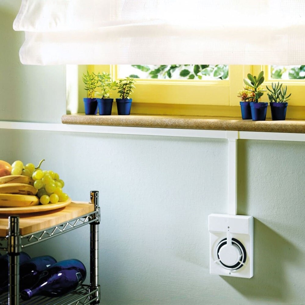 Dettaglio di una cucina con vista sulla finestra, sotto la quale è installato un minicanale a parete TMC Bocchiotti, utilizzato per il collegamento alla ventola di aerazione.