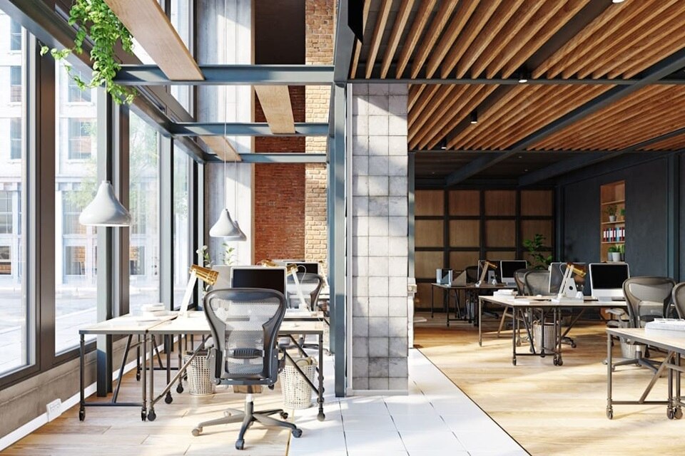 Ufficio con scrivanie e una colonna centrale rivestita in mattonelle, sulla quale è installato un minicanale TMC verticale. Sulla parete sinistra, sotto le finestre, corre un canale battiscopa TBA con scatola porta apparecchi integrata.