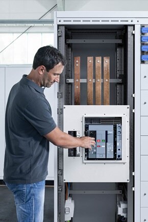 Tecnico che lavora su un quadro di distribuzione elettrica principale quadro evo di Hager, con componenti modulari installati e cablaggi in fase di intervento.