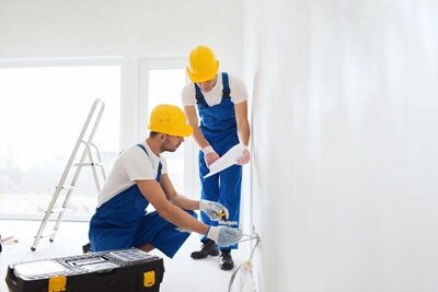 Due elettricisti professionisti al lavoro su un impianto elettrico, durante installazione o manutenzione in un ambiente domestico o commerciale.
