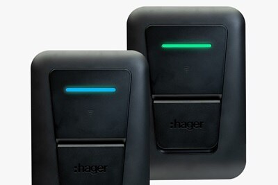 Vista frontale di due colonnine di ricarica witty one Hager su sfondo grigio, con LED verde (ricarica completata) e LED blu (in ricarica).