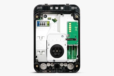 Vista frontale della colonnina di ricarica witty one Hager con sportello aperto e componenti meccanici interni a vista, su sfondo grigio neutro per facilitare la comprensione dell’installazione e della manutenzione da parte dei professionisti. 