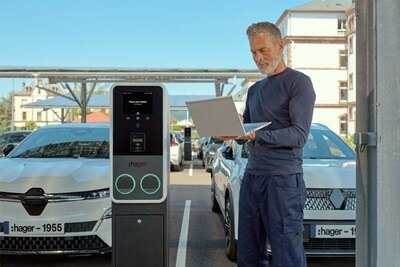 Stazione di ricarica per veicoli elettrici Hager Witty Park 2 con un uomo che la configura o la gestisce tramite laptop.