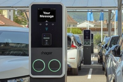 Parcheggio parzialmente coperto per auto elettriche con pannelli solari sul tetto. In primo piano una colonnina di ricarica witty Park 2 con due punti di ricarica