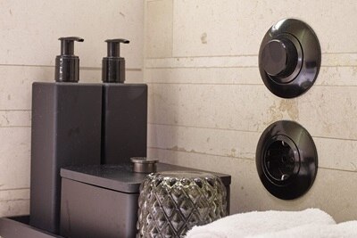 Vista di un bagno con interruttore della luce retrò Berker e presa nera della serie 1930, insieme agli accessori per il bagno.