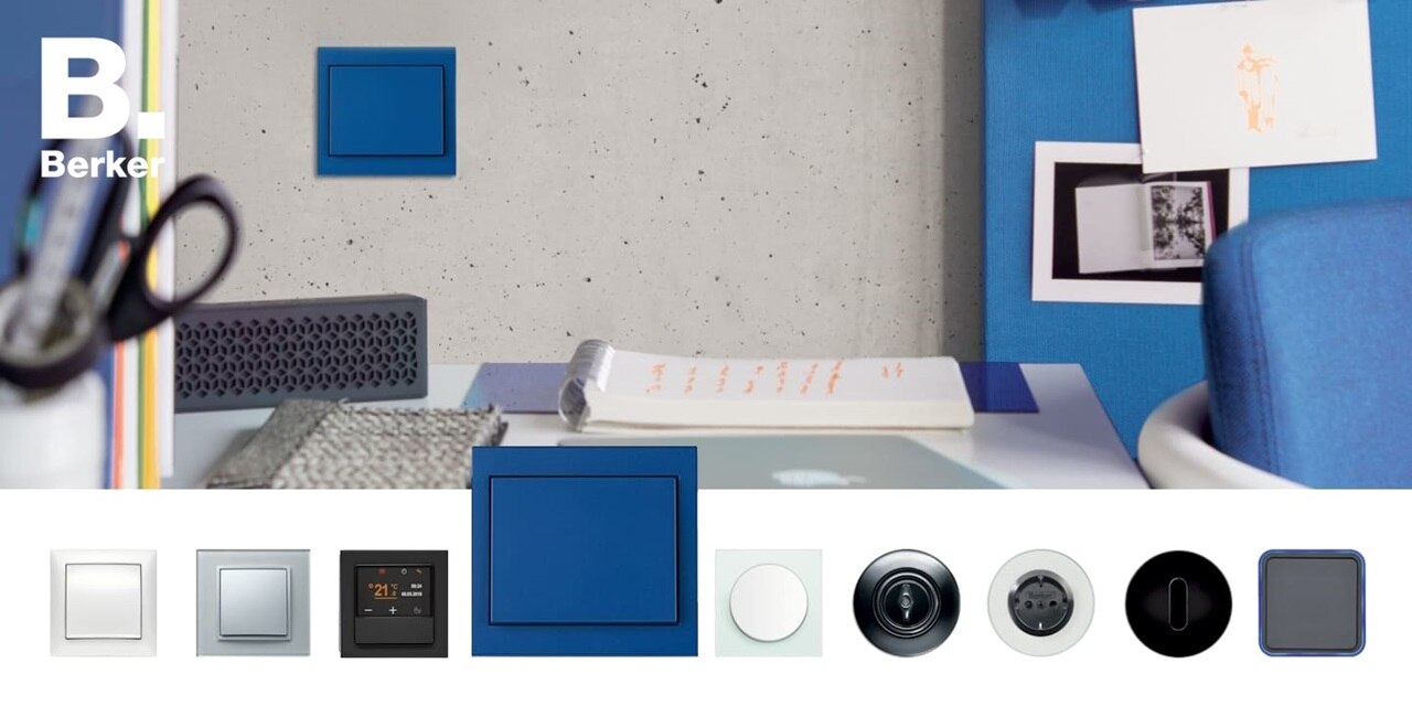 Interruttore Berker K.1 di colore blu installato su una parete in cemento, in un ambiente d’ufficio con dettagli e accessori blu. Nella parte inferiore sono mostrati diversi modelli e finiture di interruttori e placche Berker.