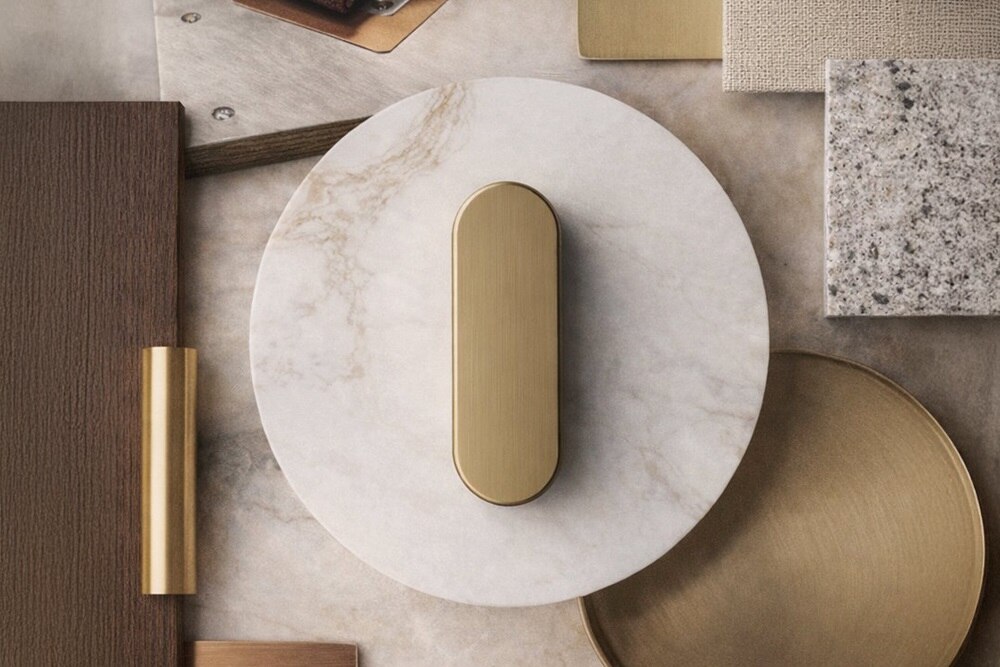 Interruttore R.classic Hager personalizzato Manufaktur in marmo con interruttore rotativo dorato appoggiato su scrivania con altri elementi di decor design