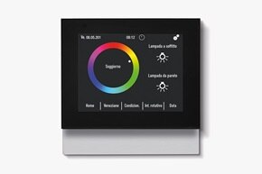 Vista frontale dell'unità di controllo ambiente Berker Touch Control e del regolatore di temperatura con ampio display a colori in nero su sfondo neutro