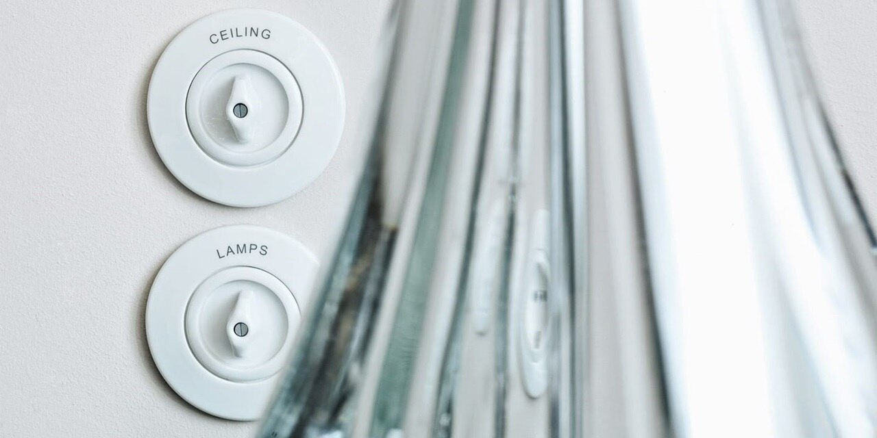 Esempio di installazione di un interruttore della luce Berker Serie 1930 con manopola e placche di copertura bianche ed etichettatura su una parete grigia