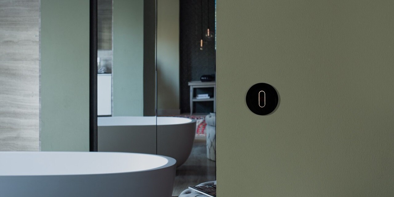 Esempio di installazione dell'interruttore della luce Berker R.classic con manopola e placca di copertura in nero su una parete verde di un bagno