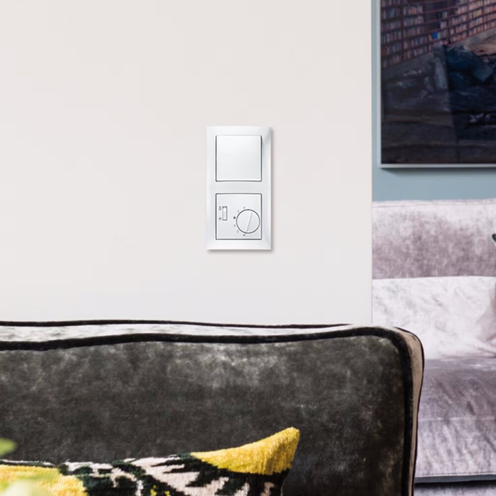 Esempio di installazione di un regolatore di temperatura Berker 20298989 per pompe di calore con interruttore riscaldamento/raffreddamento e di un pulsante montati a parete in posizione verticale in cornice Berker S.1 in bianco polare lucido a due moduli