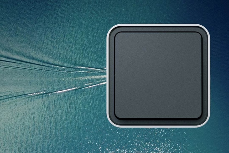 Interruttore della serie civile da esterno Berker W.1 in primo piano e in secondo piano, come sfondo, il mare con una scia che sembra partire dal prodotto.