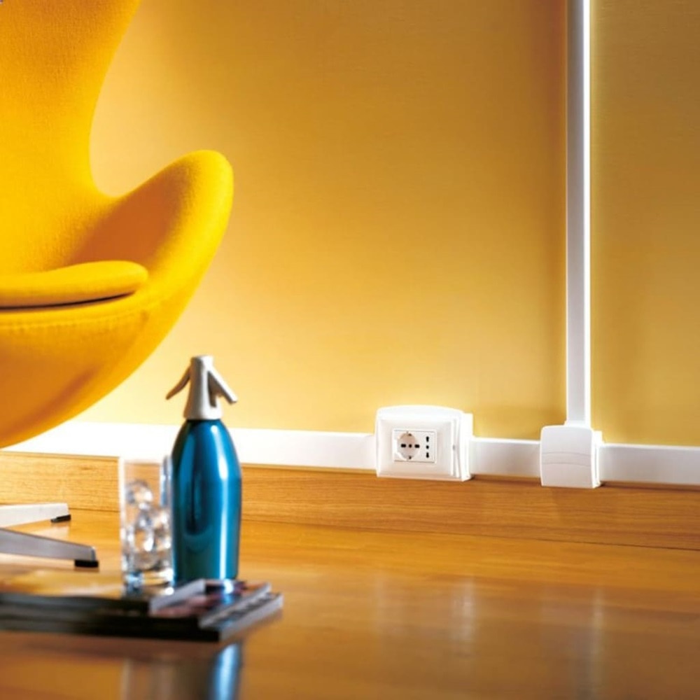 Dettaglio di una sala d’aspetto con sistema di canale porta apparecchi DESIGN Bocchiotti, dotato di scatola bianca con presa integrata.