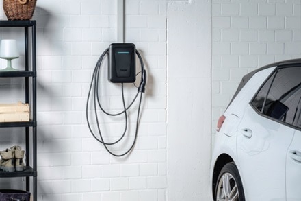 Colonnina witty one Hager con frontalino nero montata a parete all'interno di un garage residenziale.