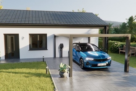 Rendering 3D di colonnina di ricarica witty one Hager con frontalino nero, installata a parete sull’esterno di una villetta residenziale.