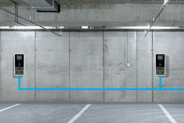 Due stazioni di ricarica per veicoli elettrici Hager Witty Park 2 montate su una parete di cemento in un parcheggio sotterraneo.