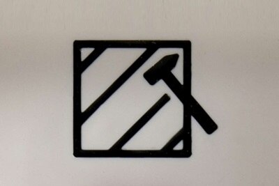 Dettaglio della pittografia martello rottura vetro posto sopra il pulsante rosso illuminabile del centralino di emergenza Pablo IP55 CE PULS R.