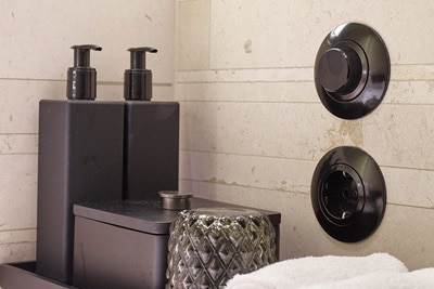 Vista di un bagno con interruttore della luce retrò Berker e presa nera della serie 1930, insieme agli accessori per il bagno.