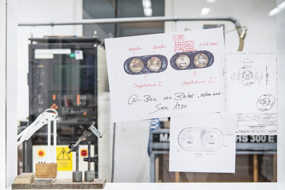 Postazione scrivania dell'ufficio ricerca della manifattura Hager con in primo piano disegni fatti a mano di interruttori personalizzati per un progetto dedicato