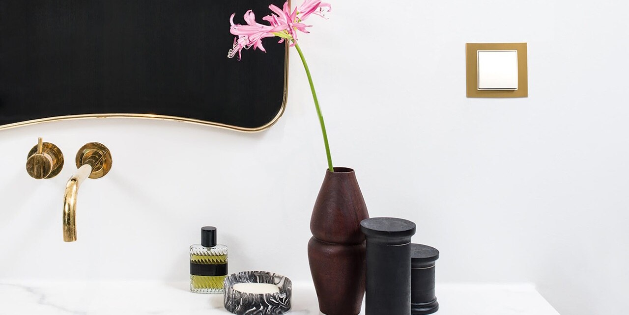 Esempio di installazione dell'interruttore della luce Berker B.3 con bilanciere bianco e cornice dorata, abbinato alla rubinetteria del bagno