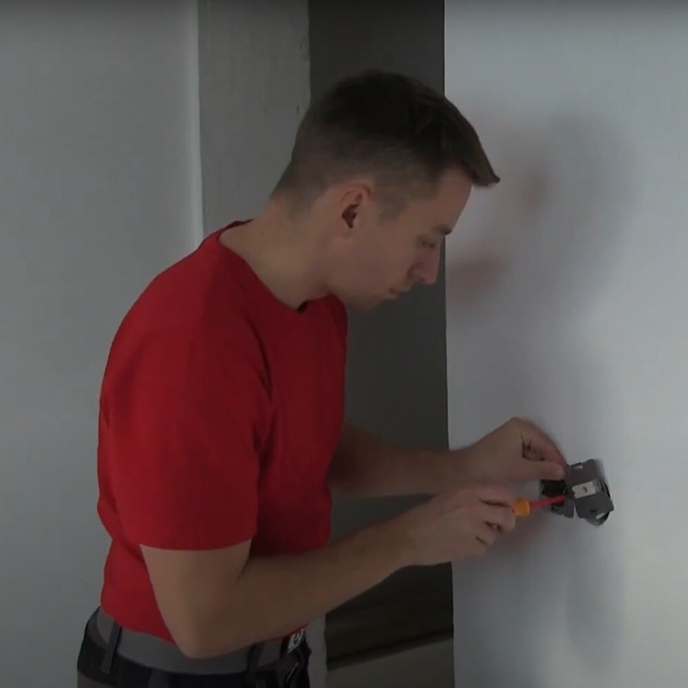 Installatore di spalle intento a montare un telaio berker a parete