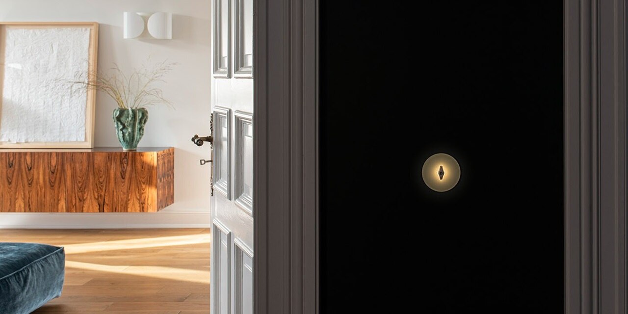 Esempio di installazione di un interruttore della luce Berker Serie 1930 con traversino retroilluminato di colore nero e cornice in vetro su una parete nera