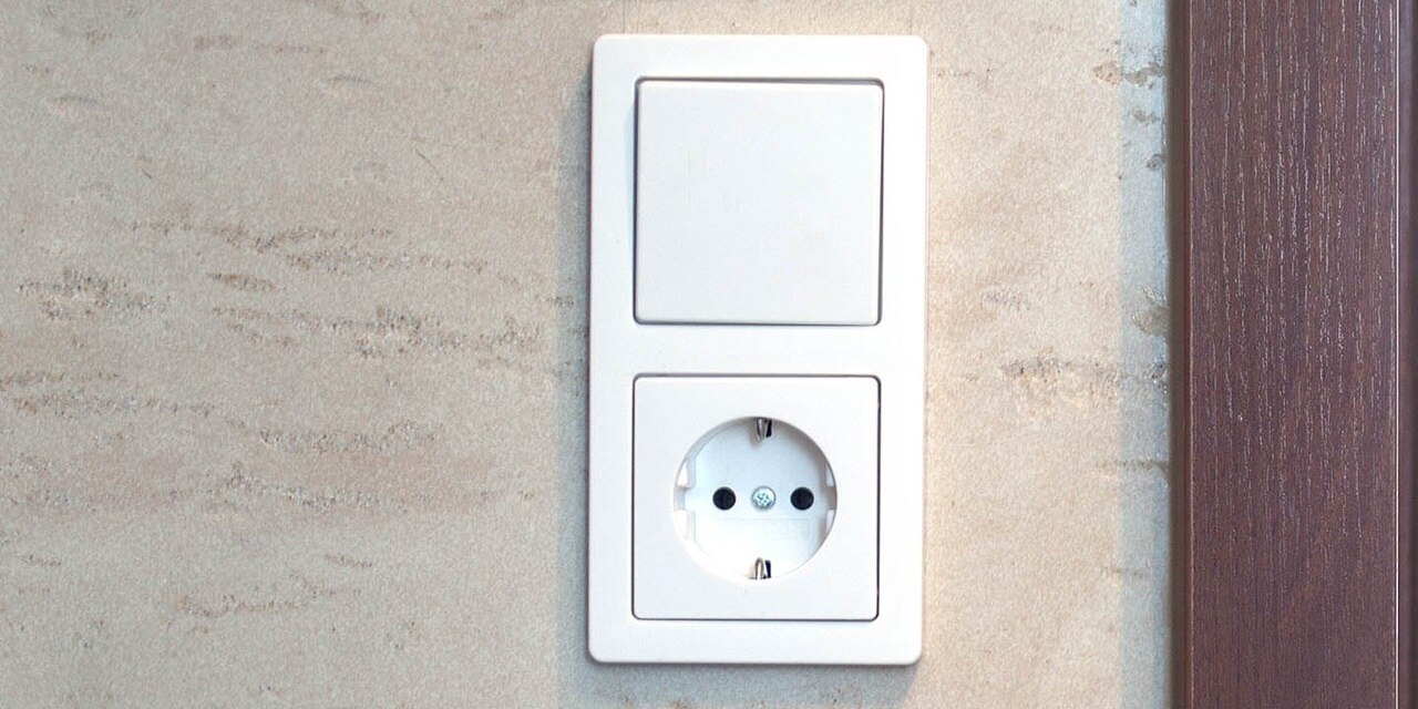 Esempio di installazione di un interruttore e presa shuko  Berker Q.1 in cornice a due moduli posiizonata in verticale in bianco su una parete intonacata