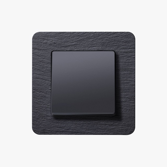 Vista frontale dell’interruttore nero a un pulsante della linea di serie civili di design Berker Q.7. su sfondo grigio 