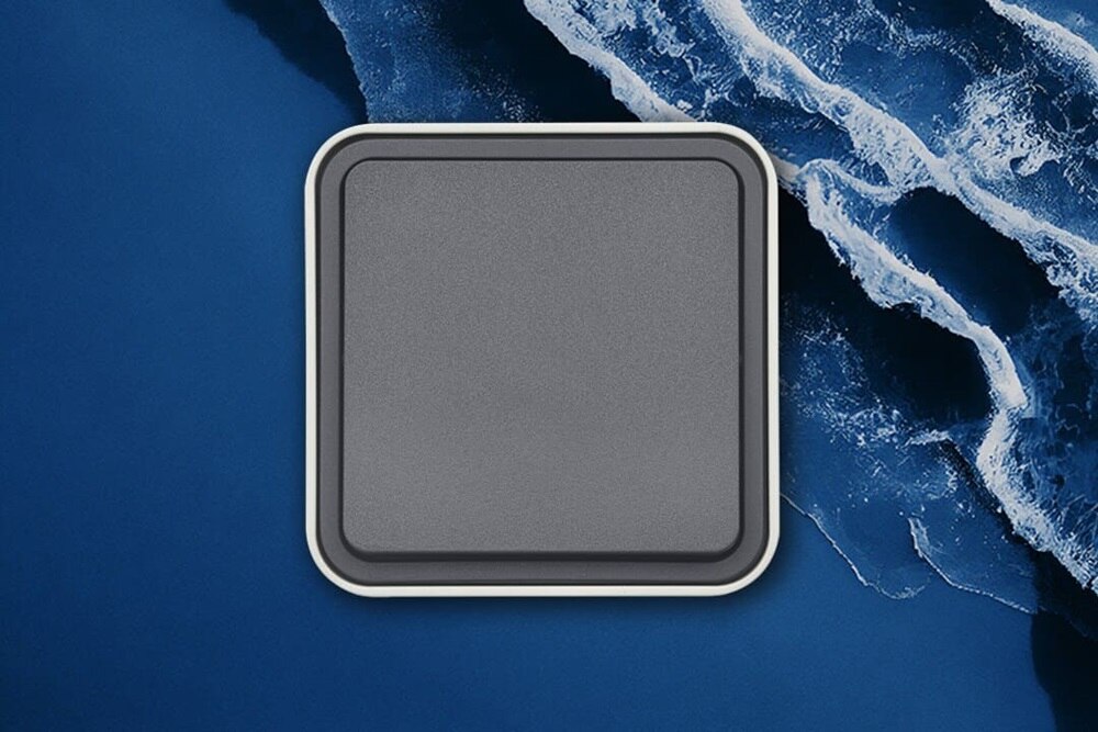 Vista frontale dell'interruttore della luce Berker W.1 in grigio su sfondo blu con onde d'acqua