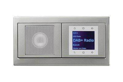 Vista frontale della radio da incasso Berker con display LCD ed elementi di comando in bianco con cornice doppia in alluminio della serie di interruttori e prese K.5