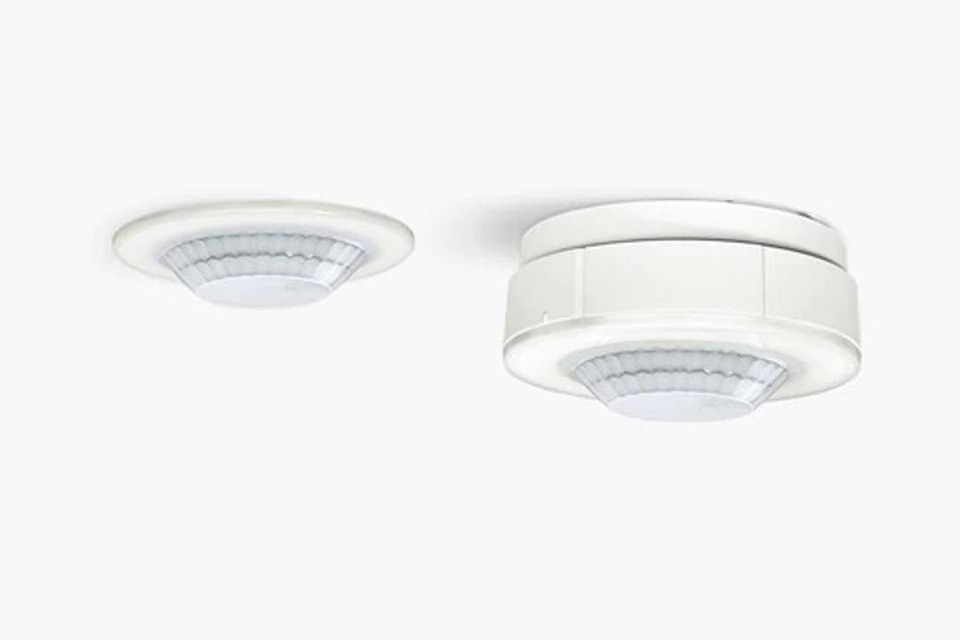 Two white ceiling-mounted smoke detectors on a plain background