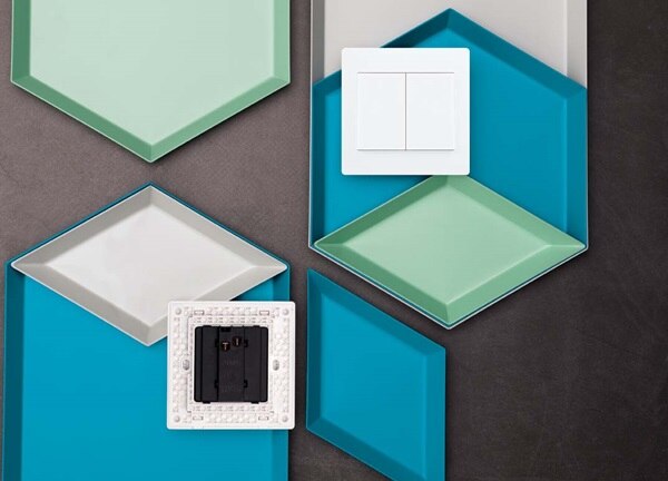 Assorted wall plates and a double light switch on a two-tone background
