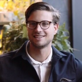 Smiling person with glasses in a casual business setting